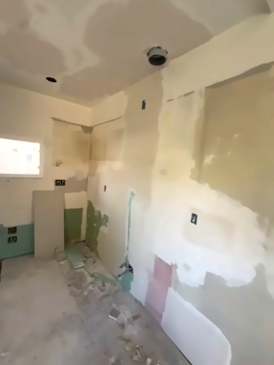 The same kitchen stripped to bare drywall and backer board with the floor torn up, before the rebuild